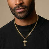 Gold crucifix pendant on a light gray background